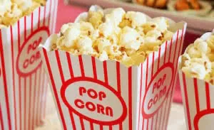 Red and white striped popcorn containers filled with buttered popcorn