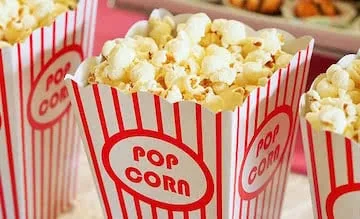 Red and white striped popcorn containers filled with buttered popcorn