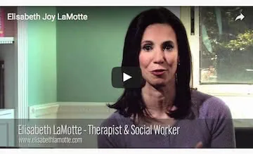 Woman with dark hair wearing purple top speaking in front of green wall, identified as Elisabeth LaMotte, Therapist & Social Worker
