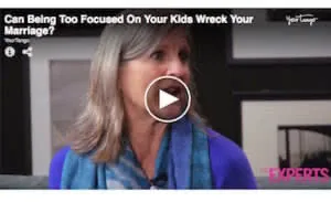 Woman with gray hair wearing blue top and blue-green scarf speaking in video interview