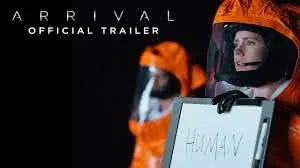 Figure in orange hazmat suit holding sign reading "HUMAN" against dark background with "ARRIVAL OFFICIAL TRAILER" text