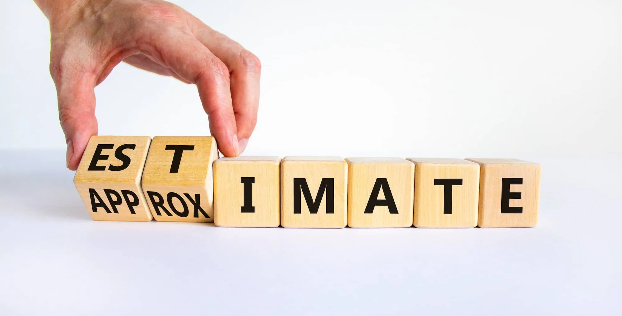 Hand flipping wooden blocks to change text from 'Estimate Appro' to 'Intimate'